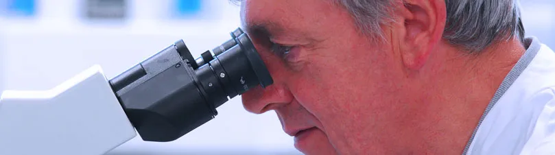 Scientist Looking Down Microscope